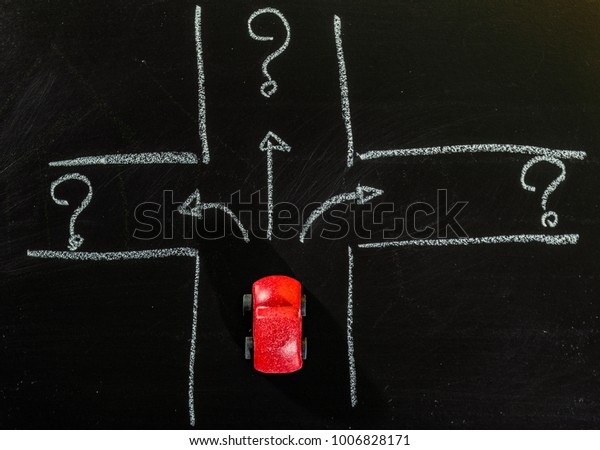 Red\
wooden car toy stop on crossroad of chalk\
board