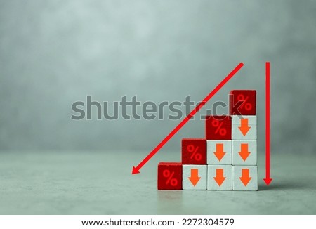 Red wooden cubes with icon percentage above arrow pointing down. The direction of an arrow symbolizing that the interest rates are going down. Financial concept and copy space 商業照片 © 