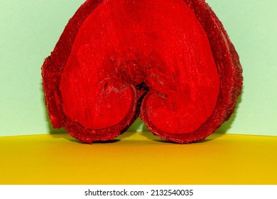 a red wooden heart that looks like a woman's cleavage