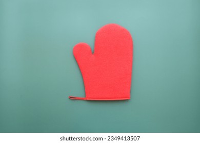 red wool winter glove on green background, christmas decoration