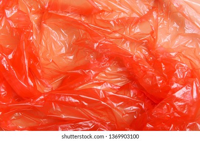 Red Wrap, Package Polypropylene, Plastic Packaging On A Beige Background. Plastic Pollution Concept. Top View, Flat Lay, Texture