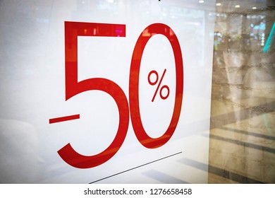 red writing "-50%", in the window of an Italian clothing and fashion store, during the winter sales in January. - Shutterstock ID 1276658458