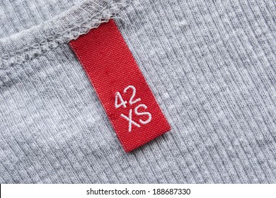 Red XS Size Label On Gray Knitted Cloth