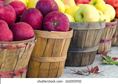 Red And Yellow Apples With Fall Leaves In Bushel Baskets