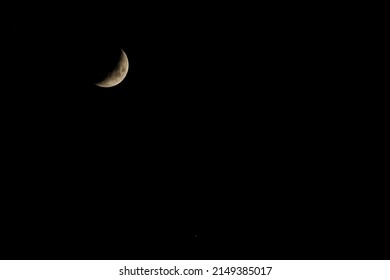 A Red Yellow Crescent Moon On A Clear Winter Night.