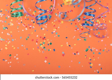 Red, yellow and green heart and circle confetti on a ORANGE background.