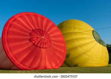 Red And Yellow Hot Air Balloons On A Ground With Blue Sky Background