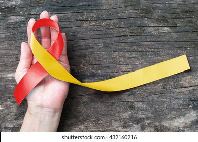 Red yellow ribbon awareness on helping hand for World hepatitis day, HIV/ HVC co-infection   