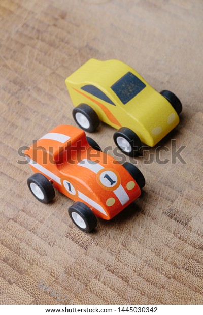 Red and yellow toy\
car on a wooden surface