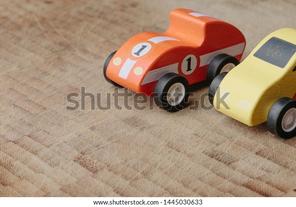 Red and\
yellow toy handmade  car on a wooden\
surface