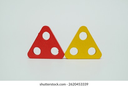Red and yellow triangular shape with circular cutouts on white background. Highlighting geometric and abstract concepts