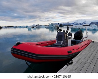 Red zodiac boat in Jökulsarlon glacier lagoon at sunset. . High quality photo