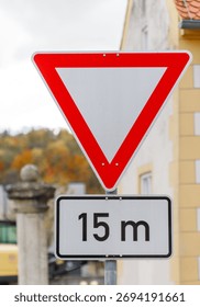 A red-bordered white triangular yield sign is mounted above a rectangular sign displaying 