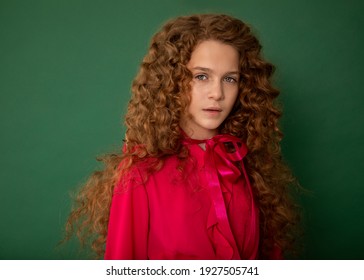 Redhair Beautiful Girl With Curly Afro Curls In Bright Pink Blouse On Green Background. Curly Hair Care, Freckle Cream, Teen Book Cover. Close-up Fashion Photo