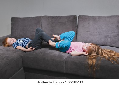 Red-haired Brother And Sister Play With Their Feet On The Couch