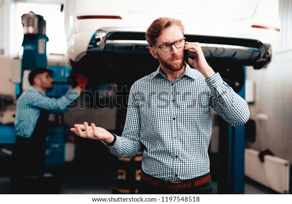 Red-haired Car
Owner Talking On The Phone. Service Station. Car Repairing With
Wrench. Solving Problems In The Garage. Customer And Performer.
Under The Vehicle. Young Auto
Mechanic.