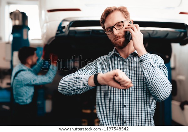 Red-haired Car\
Owner Talking On The Phone. Service Station. Car Repairing With\
Wrench. Solving Problems In The Garage. Customer And Performer.\
Under The Vehicle. Young Auto\
Mechanic.