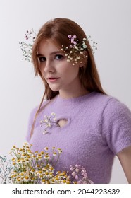 Red-haired Girl In 2000s Clothes With A Bouquet Of Flowers On A Light Background