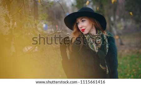 Similar – Portrait of smiling blonde woman with hat while she walks in nature looking into camera.