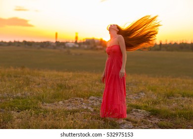 The red-haired girl in field at sunset - Shutterstock ID 532975153