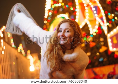 red-haired girl on the background of a Christmas tree, street
