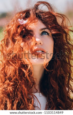 Young redhead woman covering from sun