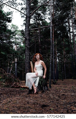 Red-haired girl in the woods. Fantasy concept