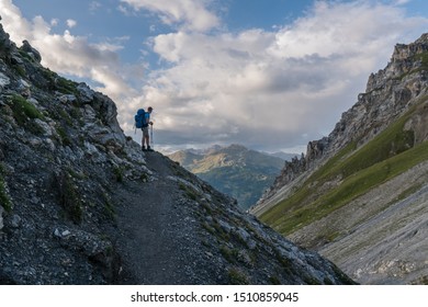 Red-haired Hiker In The Swiss Alps With Male Backpacker Enjoying Views In Val Müstair, Switzerland. Concept: Go Further And Beyond, Hero Shot, Above And Beyond
