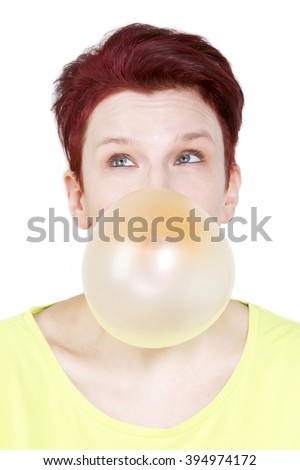 red-haired woman blowing a big bubble of chewing gum