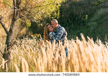 red-haired woman with a man walking rest kissing fooling around at sunset