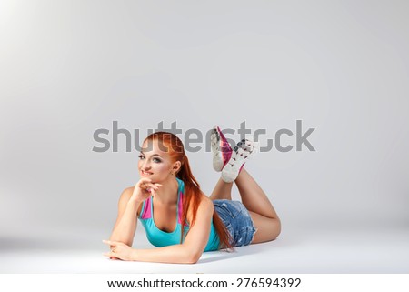 red-haired woman on a clean background is engaged in sports workout