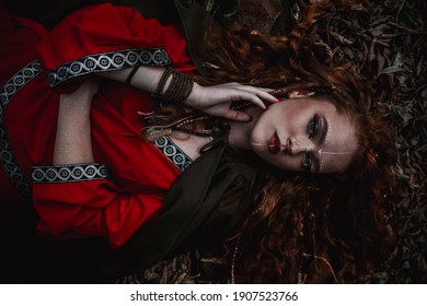 Red-haired Woman In A Red Dress In A Historical Celtic Costume In The Autumn Forest