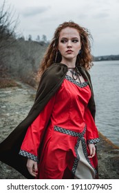 Red-haired Woman In A Red Dress In A Historical Celtic Costume In The Autumn Forest