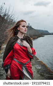 Red-haired Woman In A Red Dress In A Historical Celtic Costume In The Autumn Forest