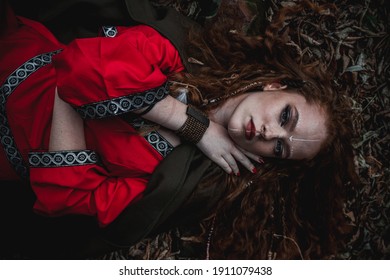 Red-haired Woman In A Red Dress In A Historical Celtic Costume In The Autumn Forest