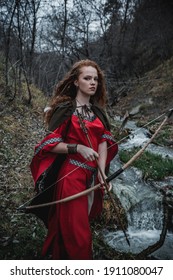 Red-haired Woman In A Red Dress In A Historical Celtic Costume In The Autumn Forest