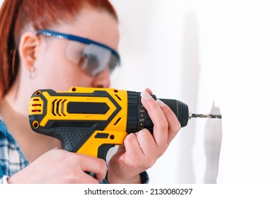 Red-haired Woman Using A Drill At Home