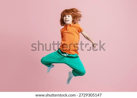 Redhead boy jumping with lively expression, personifying childhood, energy, and dynamic movement