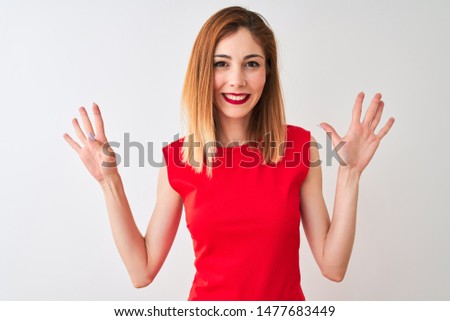 Redhead businesswoman wearing elegant red dress standing over isolated white background showing and pointing up with fingers number nine while smiling confident and happy.