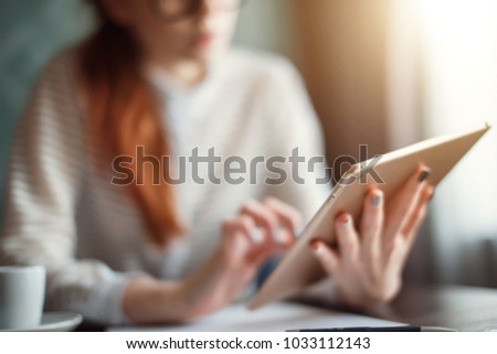 Redhead Businesswoman wearing glasses using digital tablet in office