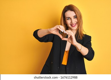 Redhead Caucasian Business Woman Over Yellow Isolated Background Smiling In Love Showing Heart Symbol And Shape With Hands. Romantic Concept.