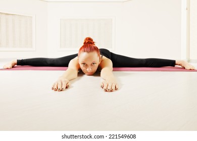 Redhead Exercising Yoga Laying Down On Floor Legs Stretched