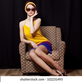 Redhead girl in armchair. 70s