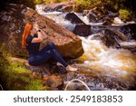 redhead girl posing at the waterfall