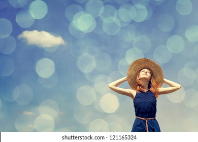 Redhead girl at spring blue sky background. Photo with bokeh at background.