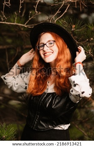 Redhead girl wearing a hat in the woods