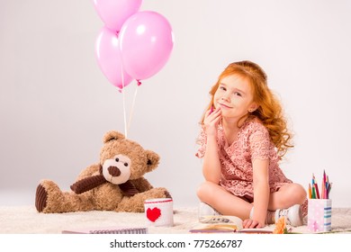 Redhead Kid Sitting On Carpet With Teddy Bear And Balloons