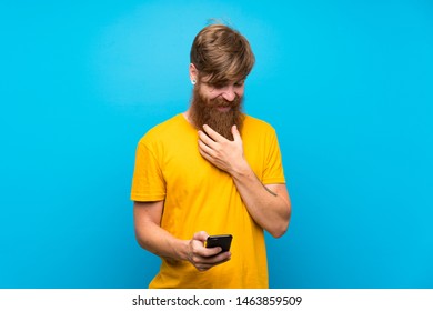 Redhead Man With Long Beard Over Isolated Blue Background Thinking And Sending A Message