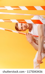 Redhead Man In White On Yellow Background  With  Red And White Ribbon. Prohibition Concept. Breaking Rules Concept. No Way Concept. Stop. Obsticle