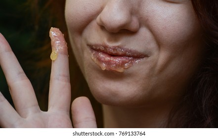 Redhead model using a homemade lip scrub made out of honey, sugar and olive oil 